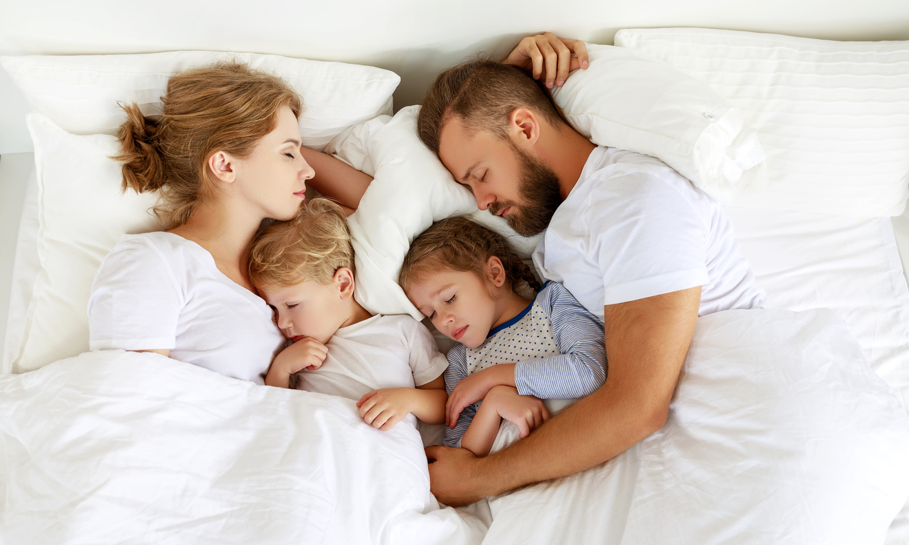 healthy sleep. happy family parents and children sleeping in white bed at home